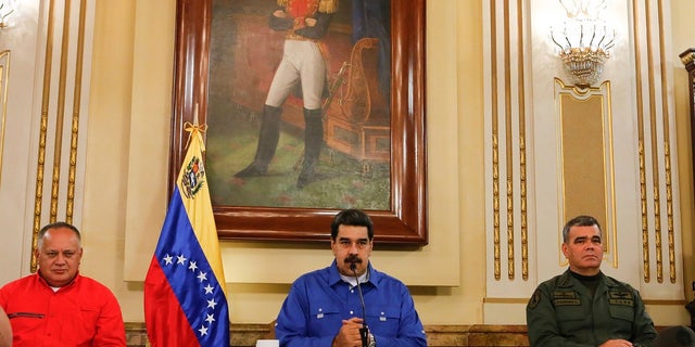 Venezuela's President Nicolas Maduro, center, flanked by Venezuela's Defense Minister Gen. Vladimir Padrino Lopez, right, and the President of the Constituent Assembly Diosdado Cabello, left, speaks during a televised national message at Miraflores Presidential Palace in Caracas, Venezuela on Tuesday. (Miraflores Press Office via AP)