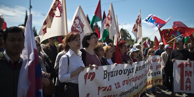 Protesters chant slogans during a rally organized by the Communist-affiliated PAME labor union outside the Greek parliament, in central Athens.