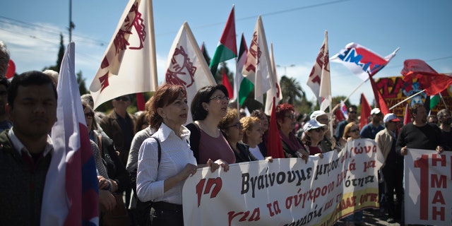 Protesters sing slogans during a rally by the Communist-affiliated PAME union outside the Greek parliament in central Athens.