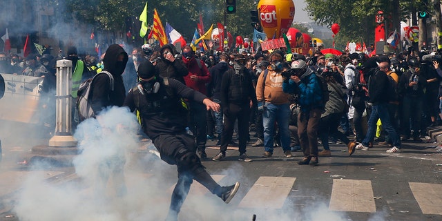 An activist kicks away a tear gas canister during a May Day demonstration in Paris. (AP Photo/Francois Mori)