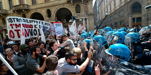 Demonstrators confront police officers as scuffles broke out during a May Day rally in Turin, Italy, Wednesday, May 1, 2019.