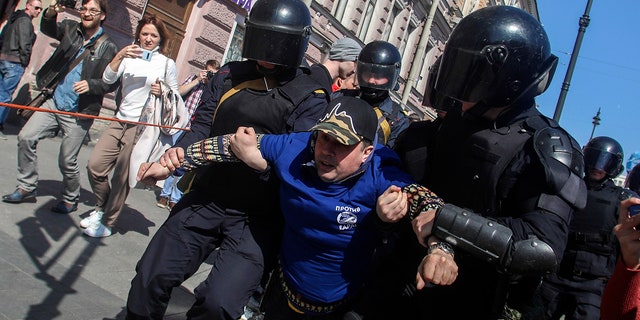 Riot police officers detain protesters during a rally in St. Petersburg, Russia, Wednesday, May 1, 2019.
