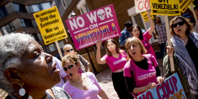 U.S. activist Medea Benjamin, co-founder of the anti-war group Code Pink, second from right, and others, sing together outside the Venezuelan Embassy in Washington, Thursday, May 2, 2019.  (AP Photo/Andrew Harnik)