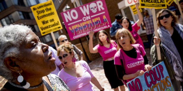 U.S. activist Medea Benjamin, co-founder of the anti-war group Code Pink, second from right, and others, sing together outside the Venezuelan Embassy in Washington, Thursday, May 2, 2019.  (AP Photo/Andrew Harnik)