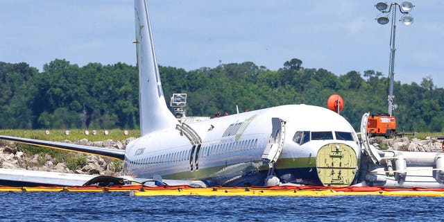 A charter plane carrying 143 people and traveling from Cuba to north Florida sits in a river at the end of a runway, Saturday, May 4, 2019 in Jacksonville, Fla. 