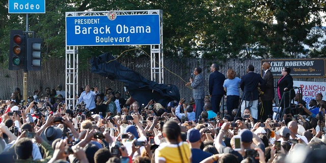 City officials, at podium on right, unveil the "President Barack Obama Boulevard" sign in Los Angeles on Saturday. (Associated Press)