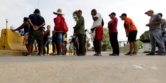 Migrants seeking asylum in the United States lining up for meals provided by volunteers near the international bridge in Matamoros, Mexico. (AP Photo/Eric Gay, File)