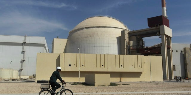 A worker rides a bike in front of the reactor building of the Bushehr nuclear power plant, outside Bushehr, Iran. (Associated Press)