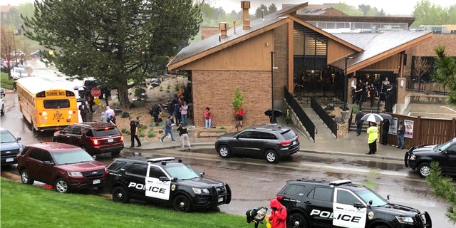 Police and others are seen outside a recreation center where students are reunited with their parents, in the Denver suburb of Highlands Ranch, Colo., after a shooting at STEM School Highlands Ranch on Tuesday.