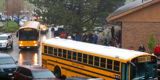 School buses arrive at a recreation center set up for students to get reunited with their parents after a shooting at a suburban Denver middle school. (Associated Press)