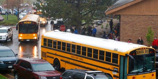 School buses arrive at a recreation center set up for students to get reunited with their parents after a shooting at a suburban Denver middle school. (Associated Press)