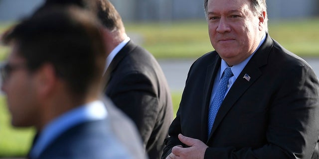 U.S. Secretary of State Mike Pompeo, right, walks to board a plane before departing from London Stansted Airport, north of London, Thursday, May 9, 2019. (Associated Press)