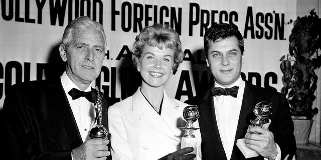 In this Feb. 26, 1958 file photo, actress Doris Day, center, Tony Curtis, right, and Buddy Adler pose with their awards presented to them by the Hollywood Foreign Press Association at its annual awards dinner in the Cocoanut Grove in Los Angeles. — AP