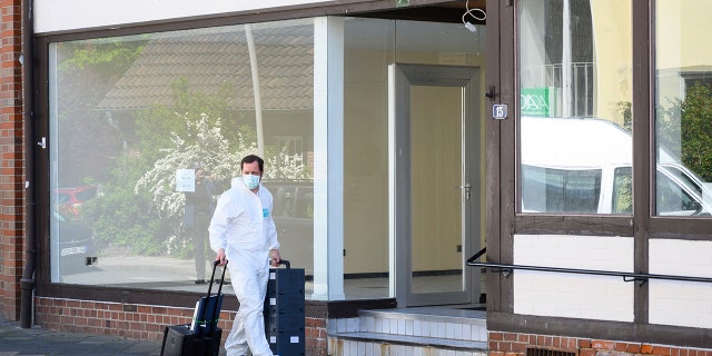 A crime scene officer arrives a crime scene where the bodies of two women have been found at an apartment in Wittingen, northern Germany, Monday, May 13, 2019. The women found dead in an apartment of one of three people who found dead on Saturday at a hotel in Passau, several hundred kilometers away in a mysterious case involving crossbows. (Christophe Gateau/dpa via AP)