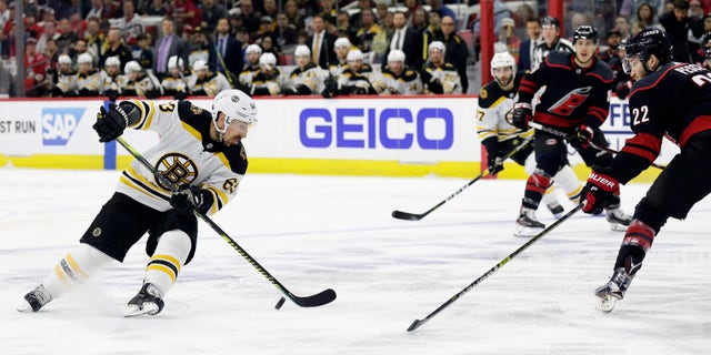 Boston Bruins' Brad Marchand (63) controls the puck against Carolina Hurricanes' Brett Pesce (22) during the first period in Game 3 of the NHL hockey Stanley Cup Eastern Conference final series in Raleigh, N.C., Tuesday, May 14, 2019. (Associated Press)
