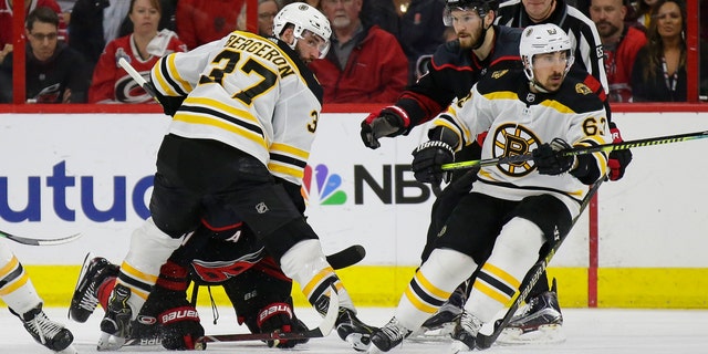 Boston Bruins' Patrice Bergeron (37) and Brad Marchand (63) skate for the puck with Carolina Hurricanes' Brett Pesce (22) and Jordan Staal during the second period in Game 3 of the NHL hockey Stanley Cup Eastern Conference final series in Raleigh, N.C., Tuesday, May 14, 2019. (Associated Press)