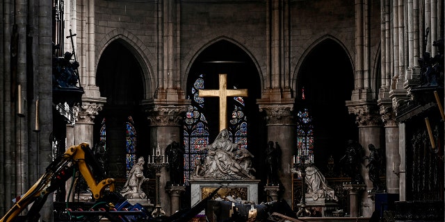 Rubble and the cross inside the Notre Dame de Paris Cathedral, Wednesday May 15, 2019 in Paris. French Culture Minister Franck Riester says that one month after a fire engulfed Notre Dame Cathedral, the edifice is still being made safe enough for restoration to begin. (Philippe Lopez/Pool via AP)