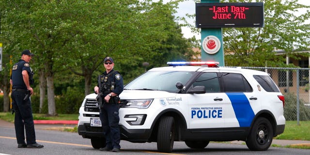 Police are positioned outside Parkrose High School during a lockdown after a man, said to be armed, was wrestled to the ground by a staff member on Friday. The Portland Police Bureau said in a statement Friday that no shots were fired and a suspect is in custody. (Dave Killen/The Oregonian via AP)