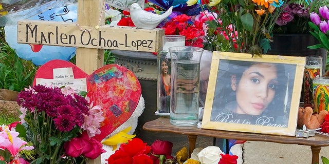 A memorial of flowers, balloons, a cross and photo of victim Marlen Ochoa-Lopez, are displayed on the lawn, Friday, May 17, 2019 in Chicago, outside the home where Ochoa-Lopez was murdered last month. (AP Photo/Teresa Crawford)
