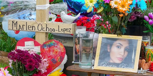 A memorial of flowers, balloons, a cross and photo of victim Marlen Ochoa-Lopez, are displayed on the lawn, Friday, May 17, 2019 in Chicago, outside the home where Ochoa-Lopez was murdered last month. (AP Photo/Teresa Crawford)