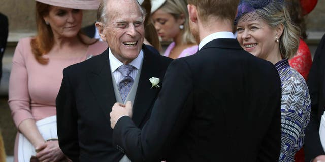 Prince Philip talks to Prince Harry, right, as they leave after the wedding of Lady Gabriella Windsor and Thomas Kingston at St George's Chapel, Windsor Castle, near London, England, Saturday, May 18, 2019.