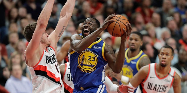 Striker Draymond Green (23) of the Golden State Warriors shoots against striker Meyers Leonard of Portland Trail Blazers, left, in the first half of the third game of the Conference Finals. West NBA, Saturday, in Portland, Oregon (Associated Press)