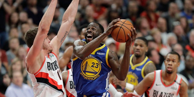 Striker Draymond Green (23) of the Golden State Warriors shoots against striker Meyers Leonard of Portland Trail Blazers, left, in the first half of the third game of the Conference Finals. West NBA, Saturday, in Portland, Oregon (Associated Press)