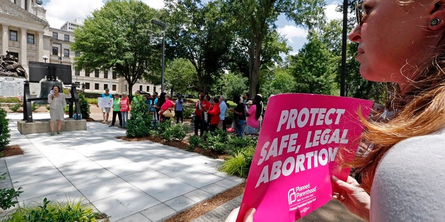 An abortion rights advocate holds signage at the Capitol in Jackson, Miss., voicing her opposition to state legislatures passing abortion bans that prohibit most abortions once a fetal heartbeat can be detected, Tuesday, May 21, 2019. The rally in Jackson was one of many around the country to protest abortion restrictions that states are enacting. (AP Photo/Rogelio V. Solis)