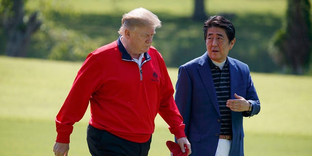 President Donald Trump walks with Japanese Prime Minister Shinzo Abe before playing a round of golf at Mobara Country Club, on Sunday, in Chiba, Japan. (Associated Press)