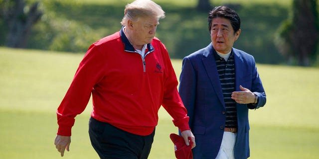 President Donald Trump walks with Japanese Prime Minister Shinzo Abe before playing a round of golf at Mobara Country Club, on Sunday, in Chiba, Japan. (Associated Press)