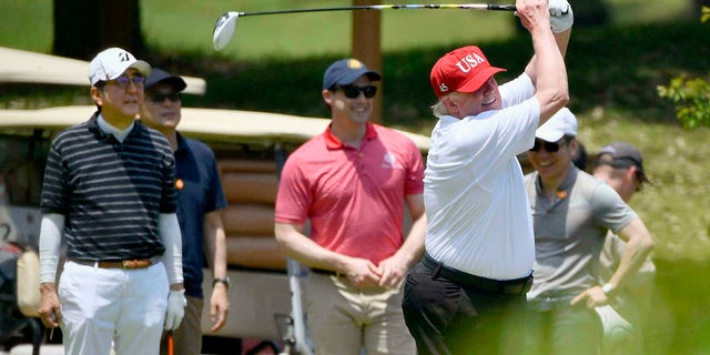 U.S. President Donald Trump, right, plays golf with Japanese Prime Minister Shinzo Abe, left, at Mobara Country Club in Mobara, south of Tokyo, on Sunday. (Associated Press)