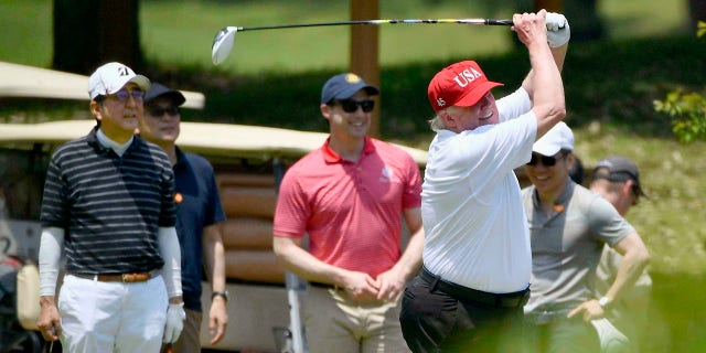 U.S. President Donald Trump, right, plays golf with Japanese Prime Minister Shinzo Abe, left, at Mobara Country Club in Mobara, south of Tokyo, on Sunday. (Associated Press)