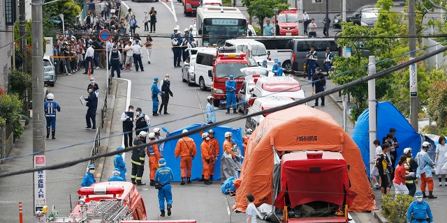 Rescuers work at the scene of an attack in Kawasaki, near Tokyo Tuesday, May 28, 2019. A man wielding a knife attacked commuters waiting at a bus stop just outside Tokyo during Tuesday morning's rush hour, Japanese authorities and media said. (Kyodo News via AP)