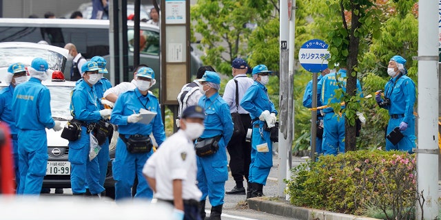 Investigators work near a bus stop for CARITAS Elementary School bus at the scene of an attack in Kawasaki, near Tokyo Tuesday, May 28, 2019. (Shigeyuki Inakuma/Kyodo News via AP)