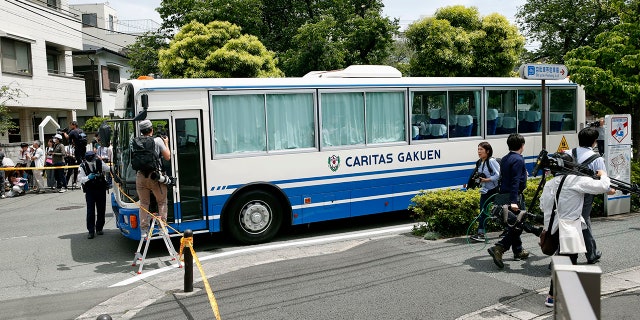 CARITAS Elementary School bus is seen near the scene where a man wielding a knife attacked commuters in Kawasaki, near Tokyo Tuesday, May 28, 2019.(Kyodo News via AP)