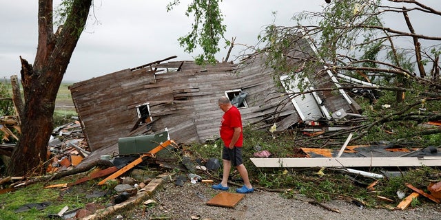 Joe Armison looking over his destroyed barn after a tornado struck the outskirts of Eudora, Kan., on Tuesday. (AP Photo/Colin E. Braley)