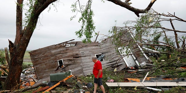 Joe Armison looking over his destroyed barn after a tornado struck the outskirts of Eudora, Kan., on Tuesday. (AP Photo/Colin E. Braley)