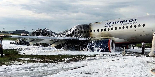 The Sukhoi SSJ100 aircraft of Aeroflot airlines is covered in fire retardant foam after an emergency landing in Sheremetyevo airport in Moscow, Russia, Sunday, May 5, 2019.