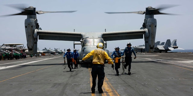 In this Friday, May 17, 2019, photo, released by the U.S. Navy, sailors work around an MV-22 Osprey as it lands on the flight deck of the Nimitz-class aircraft carrier USS Abraham Lincoln in the Arabian Sea.