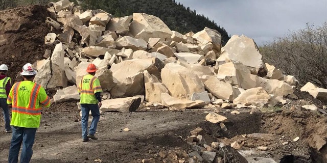 Rubble can be seen after a massive boulder was blasted into pieces after destroying a section of a highway in Colorado over the weekend.