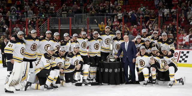 Boston Bruins players pose with the Prince of Wales trophy and Bill Daly, deputy commissioner of the National Hockey League, following Game 4 of the NHL hockey Stanley Cup Eastern Conference finals against the Carolina Hurricanes in Raleigh, N.C., on Thursday. Boston won 4-0 to advance to the Stanley Cup Final. (Associated Press)