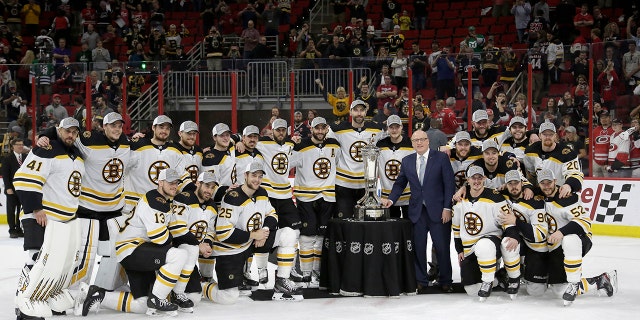 Boston Bruins players pose with the Prince of Wales trophy and Bill Daly, deputy commissioner of the National Hockey League, following Game 4 of the NHL hockey Stanley Cup Eastern Conference finals against the Carolina Hurricanes in Raleigh, N.C., on Thursday. Boston won 4-0 to advance to the Stanley Cup Final. (Associated Press)