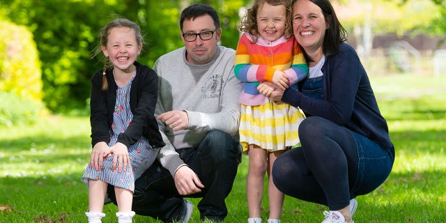 Rachel Avon, with her daughters Ffion (left) and Cari, and partner Ross, said she would have never known she had the rare cancer if her growing unborn baby wasn't pushing on the tumor to cause pain.
