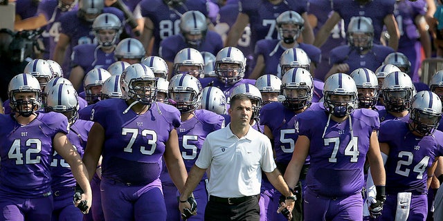 St. Thomas coach Glen Caruso leads his team on the field for a college football match against St. John's in St. Paul, Minnesota (Jim Gehrz / Star Tribune via AP)