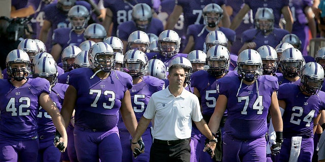 St. Thomas coach Glen Caruso leads his team onto the field for a college football game against St. John's, in St. Paul, Minn. (Jim Gehrz/Star Tribune via AP)
