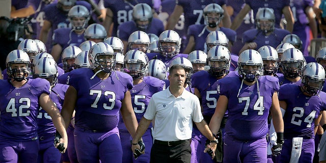 St. Thomas coach Glen Caruso leads his team on the field for a college football match against St. John's in St. Paul, Minnesota (Jim Gehrz / Star Tribune via AP)