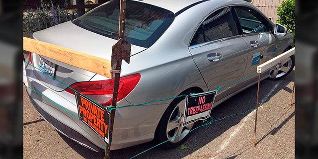 This undated photo provided by KOMO News shows a car-share vehicle parked at a Seattle duplex. Dan Smith took exception to the car2go Mercedes that has been parked there since May 17, 2019. (KOMO News via AP)