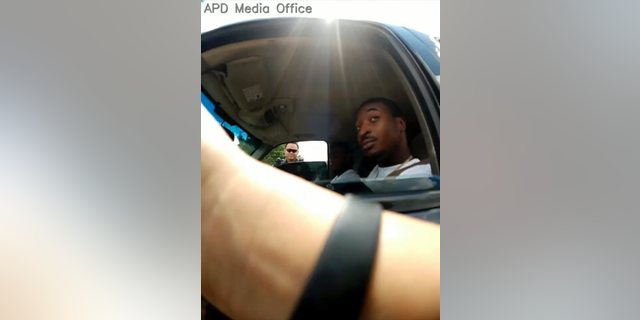 In this screenshot taken from Sept. 1, 2018, police body camera video provided by the Arlington Police Department, an officer, foreground, talks to O'Shae Terry after stopping him for a vehicle registration violation, in Arlington, Texas, as a second officer, background left, looks in from the passenger side window. Bau Tran, a Texas police officer has been fired after he was charged with criminally negligent homicide in the fatal shooting of a black man during a traffic stop last year. In a statement Friday, May 17, 2019 Arlington police announced Officer Bau Tran was fired after an internal investigation found policy violations that led to the Sept. 1 shooting of 24-year-old O’Shae Terry. (Arlington Police Department via AP, File)