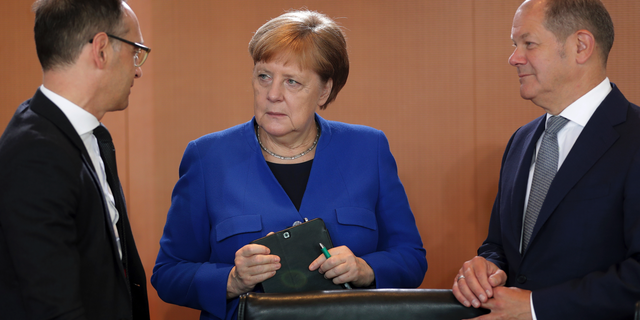 German Chancellor Angela Merkel, center, German Foreign Minister Heiko Maas, left, and German Finance Minister Olaf Scholz talk as they arrive for the weekly cabinet meeting at the chancellery in Berlin, Germany, Wednesday, May 15, 2019. (AP Photo/Michael Sohn)