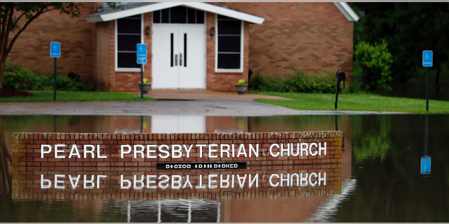 The Pearl Presbyterian Church's sign is reflected in floodwaters in Pearl, Miss., on Thursday, May 9, 2019. There is no pond on the property and the flash flooding filled up the parking lot as it surrounded the church. Strong winds, tornado warnings and substantial rains added to the flash flooding throughout Mississippi including this area of downtown Jackson, Miss., Thursday, May 9, 2019. (AP Photo/Rogelio V. Solis)